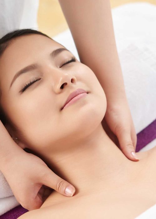 Asian woman getting a neck and shoulder massage